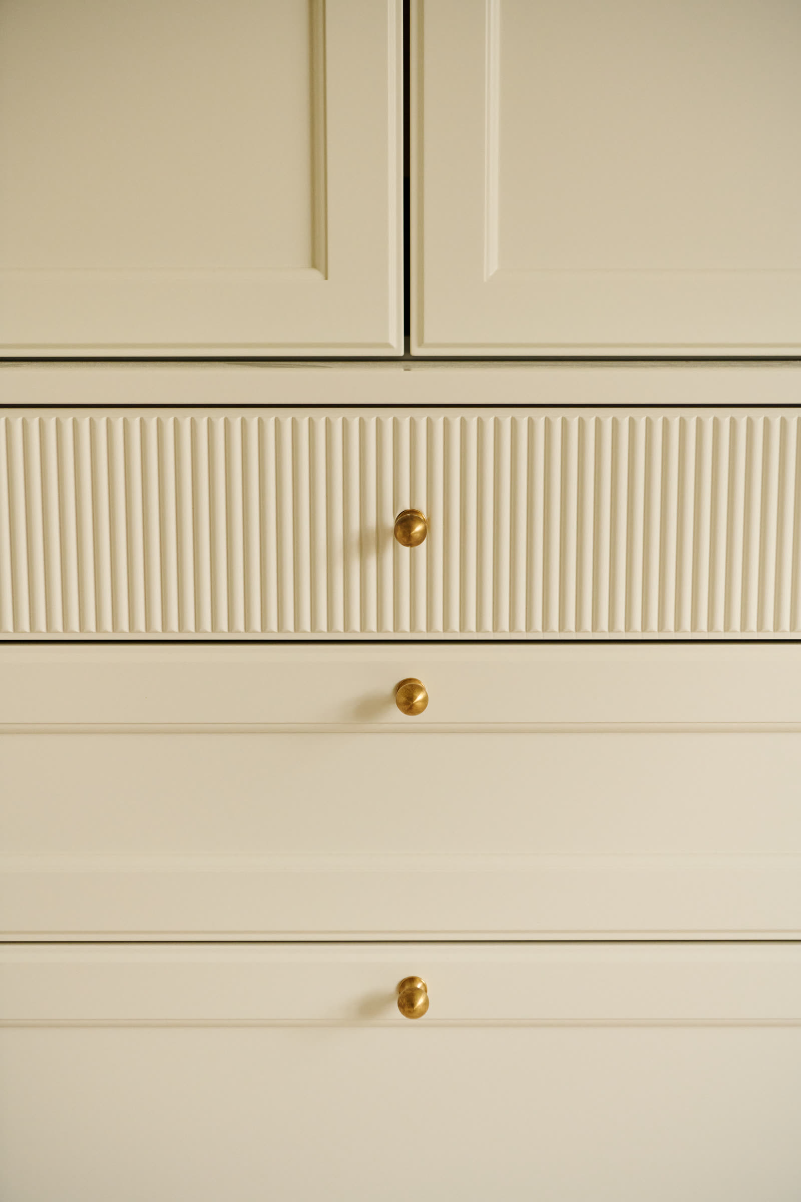 Fluted drawer fronts with brass knobs