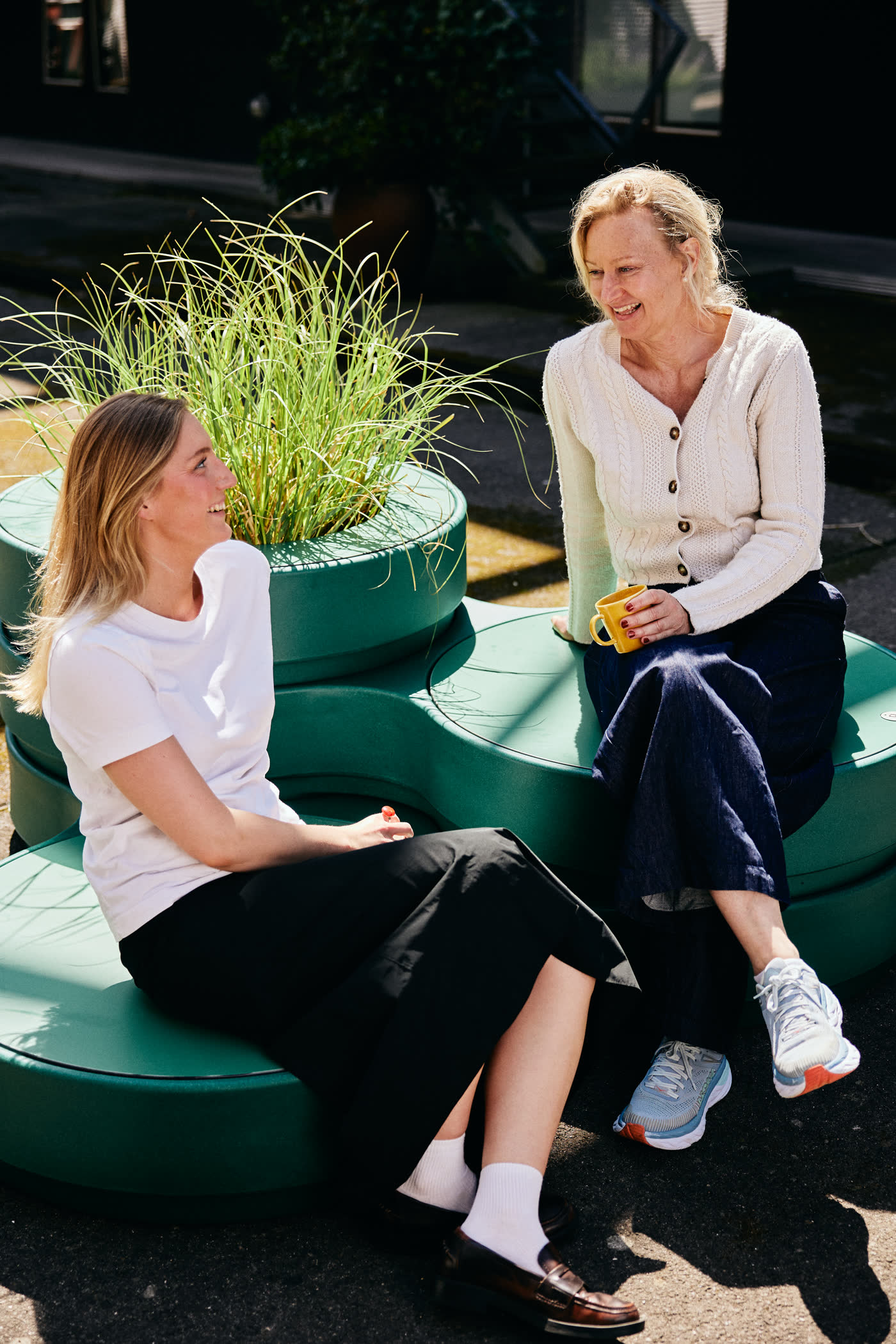 Two women talking on Circus modules with plants