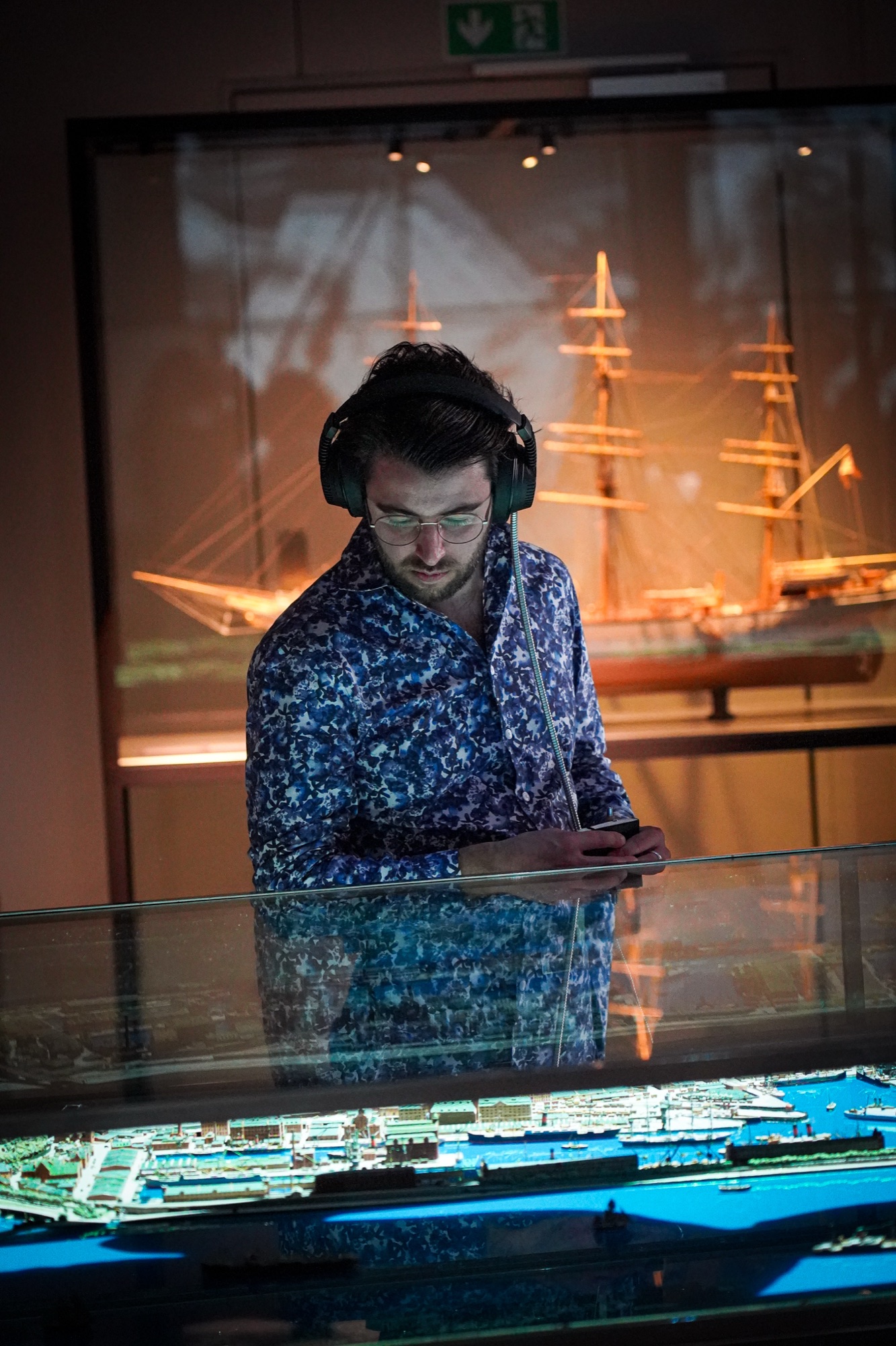 A guest listening by the model of the harbour