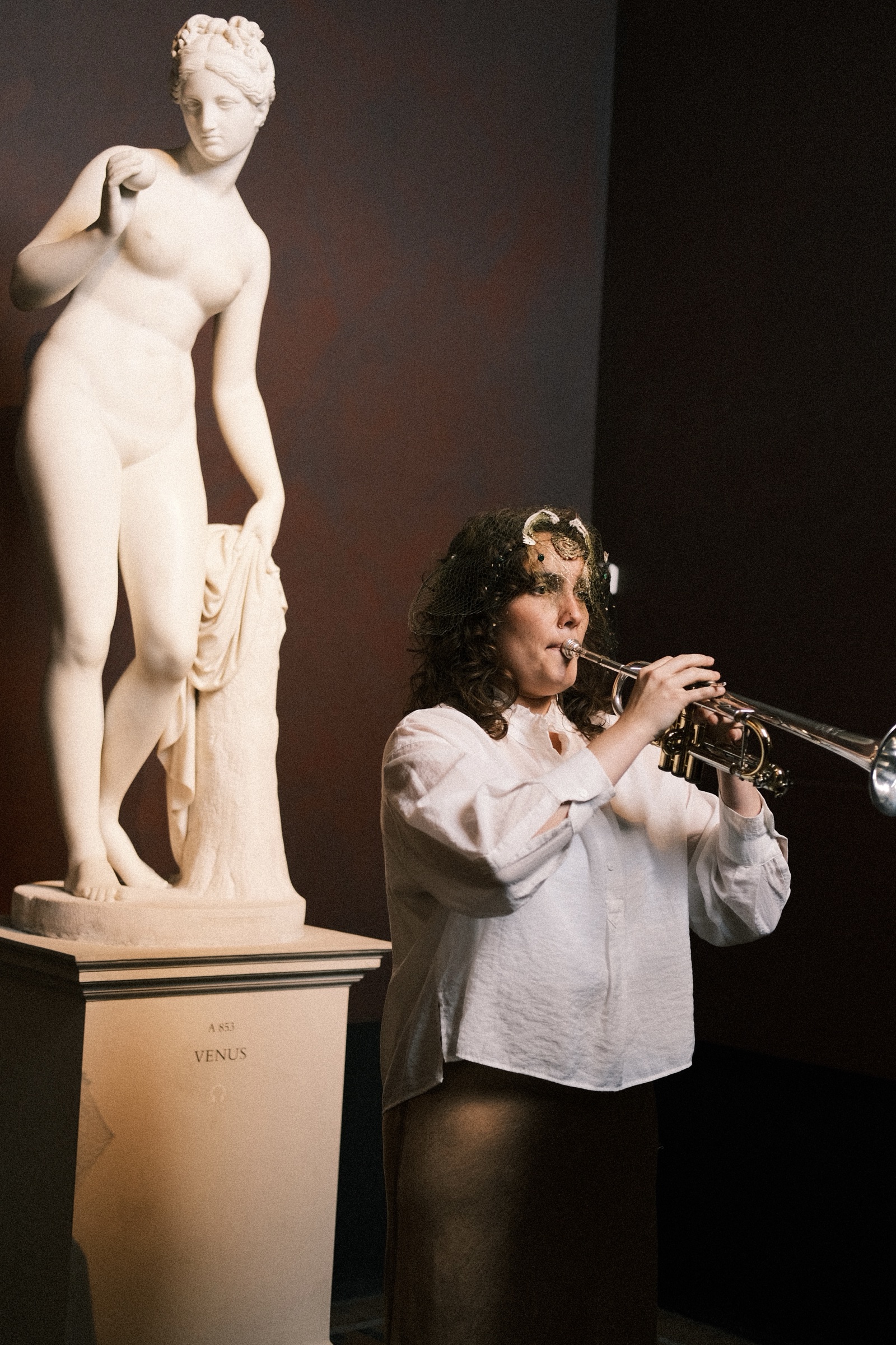 The trumpeter playing under a sculpture of Venus